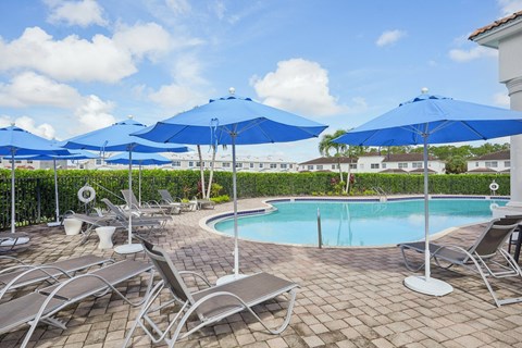 a swimming pool with umbrellas and chairs around it