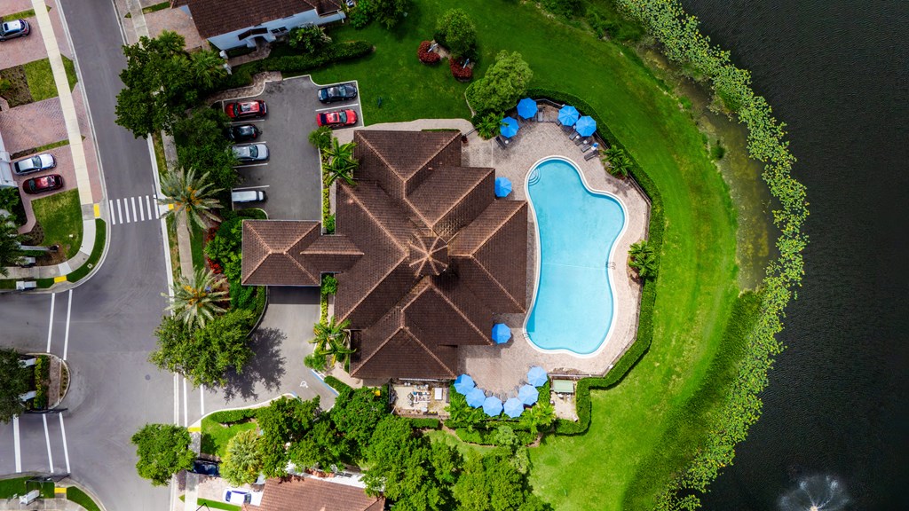A swimming pool surrounded by a grassy area and a few trees.