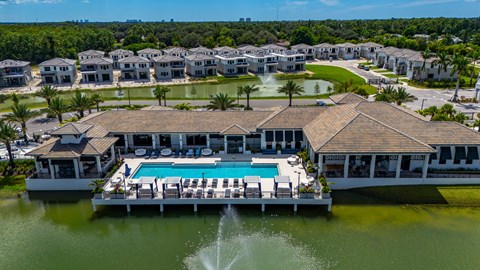 A large house with a pool in the middle of a lake.
