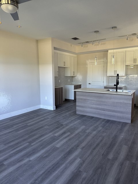 A kitchen with a grey counter top and a grey floor.