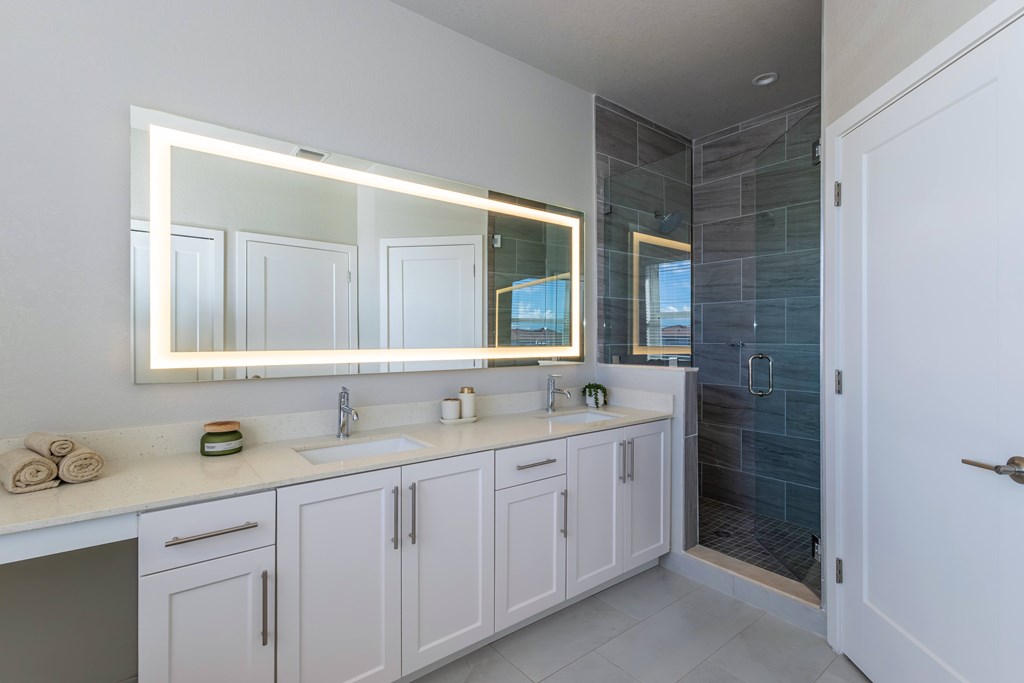 A bathroom with a large mirror above a double sink vanity.