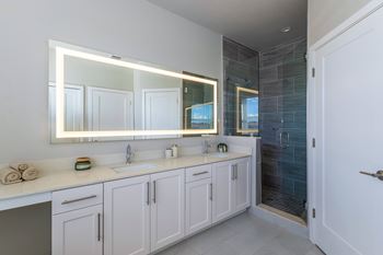 A bathroom with a large mirror above a double sink vanity.