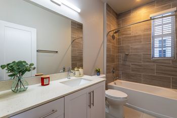 A bathroom with a white toilet, sink, and bathtub.
