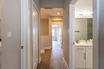 A long hallway with white walls and wood floors.