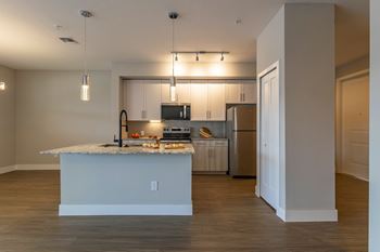 A kitchen with a white island and wooden floors.