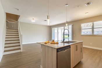 A kitchen with a dishwasher and a counter with food on it.
