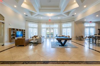 A large, well-lit living room with a central table and chairs.