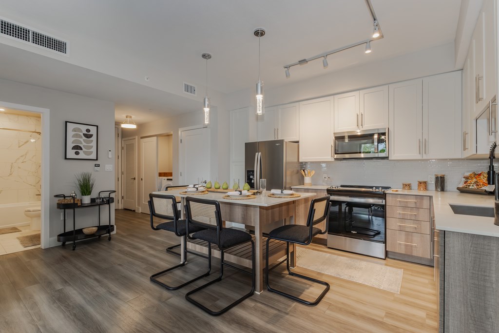 A modern kitchen with a dining table and chairs.