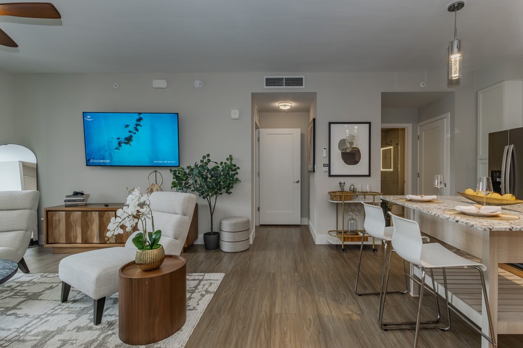 A living room with a television and a dining area.