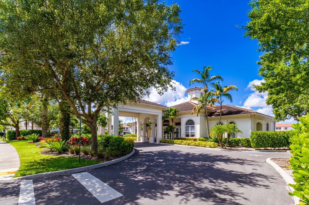A white building with a large driveway in front.