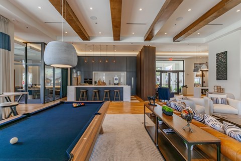 A pool table is in the middle of a living room.