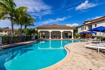 A swimming pool with a tiled edge and a sun lounger on the right.