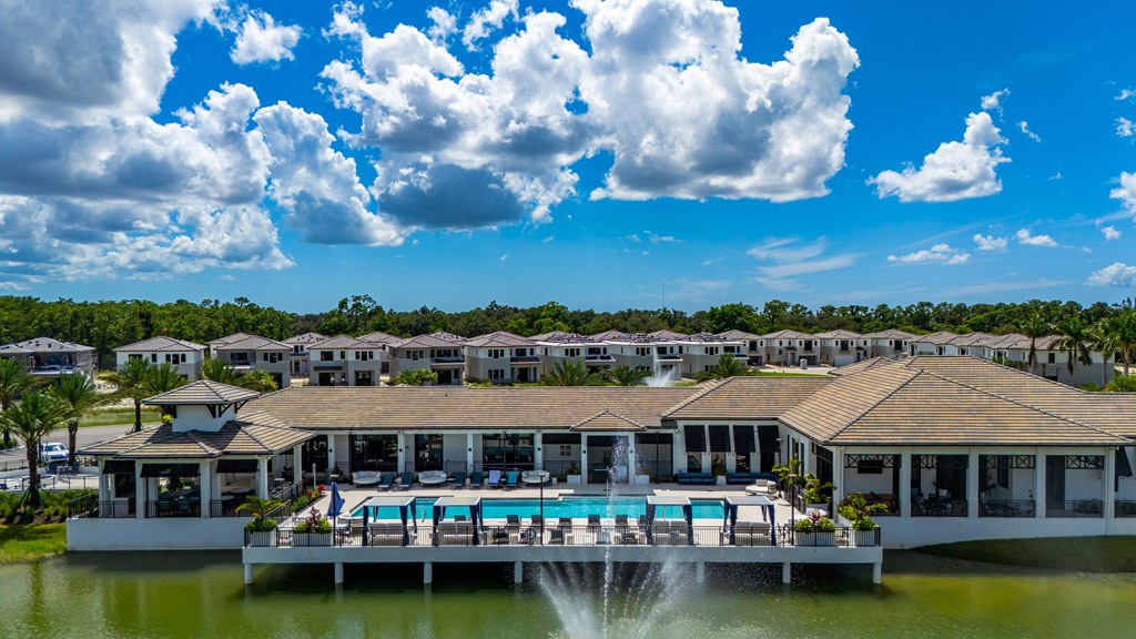 A resort with a pool and a fountain in the foreground.