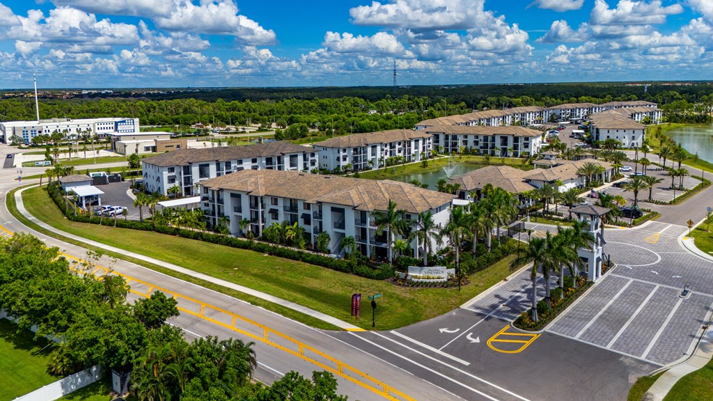 A large building complex with a parking lot in front.