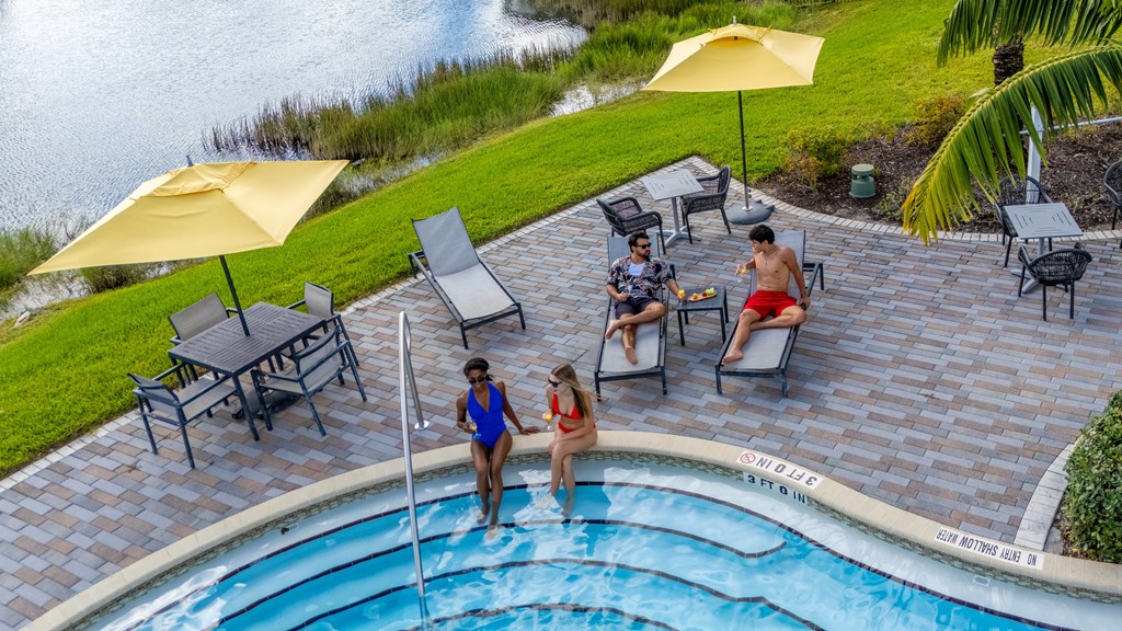 A group of people are enjoying a sunny day by the pool.
