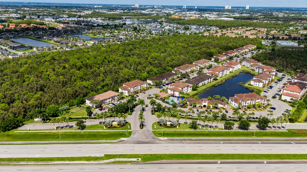 A bird's eye view of a residential area with houses, roads, and a body of water.