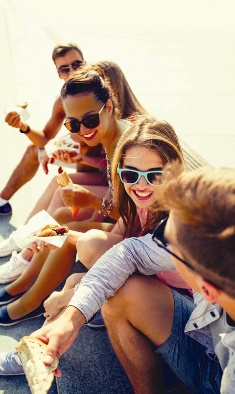 a group of people sitting on the ground eating food at The Orchard at Portofino Vineyards, Fort Myers Florida