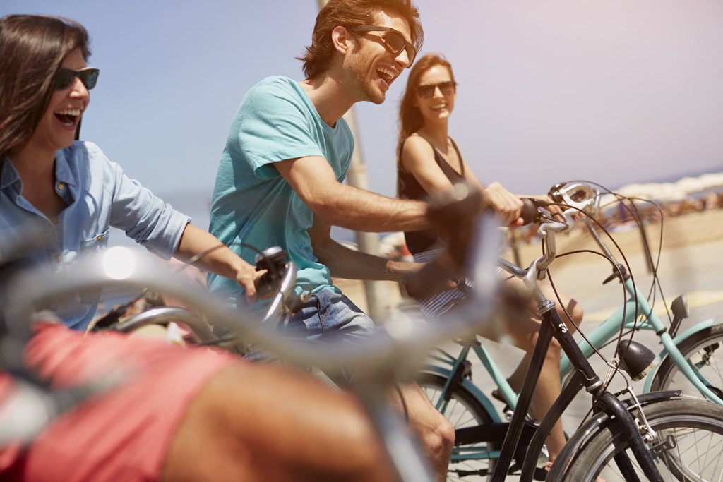 a group of people riding bikes on the beach