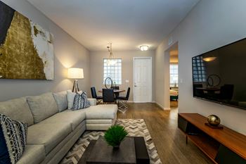 A living room with a grey couch and a wooden coffee table.