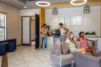 Four people are sitting on a couch in a modern living room.