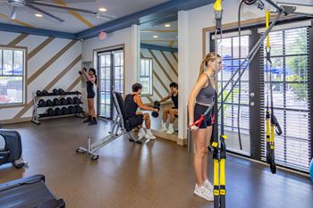 A woman is working out in a gym with a personal trainer.