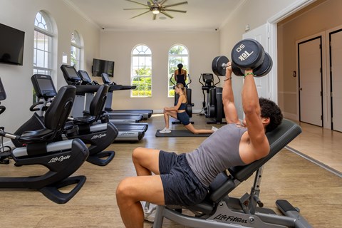 A man lifting weights in a home gym.