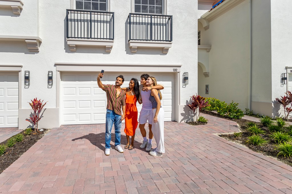 Three people taking a selfie in front of a white building.