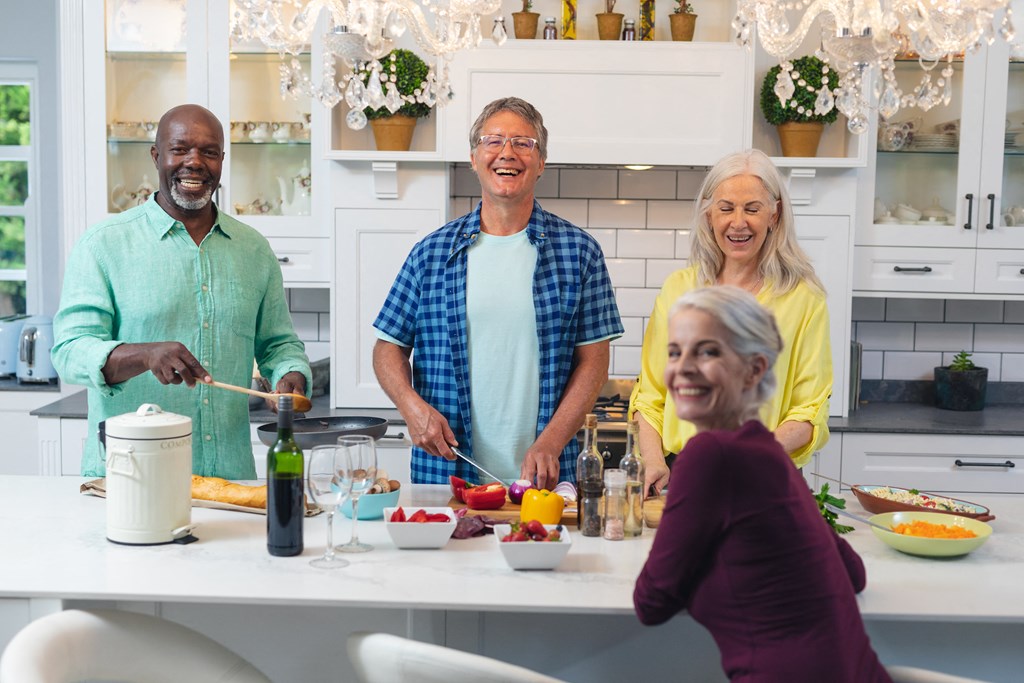 a group of people in a kitchen preparing food at The Falls of Portofino, Naples, FL