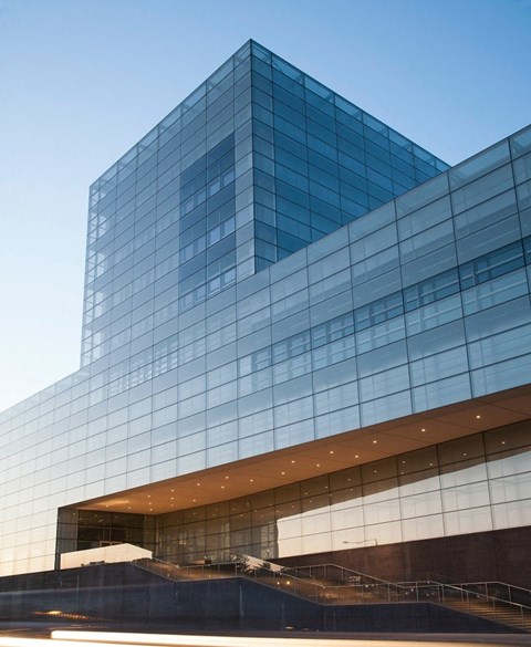 a glass building with a blue sky in the background