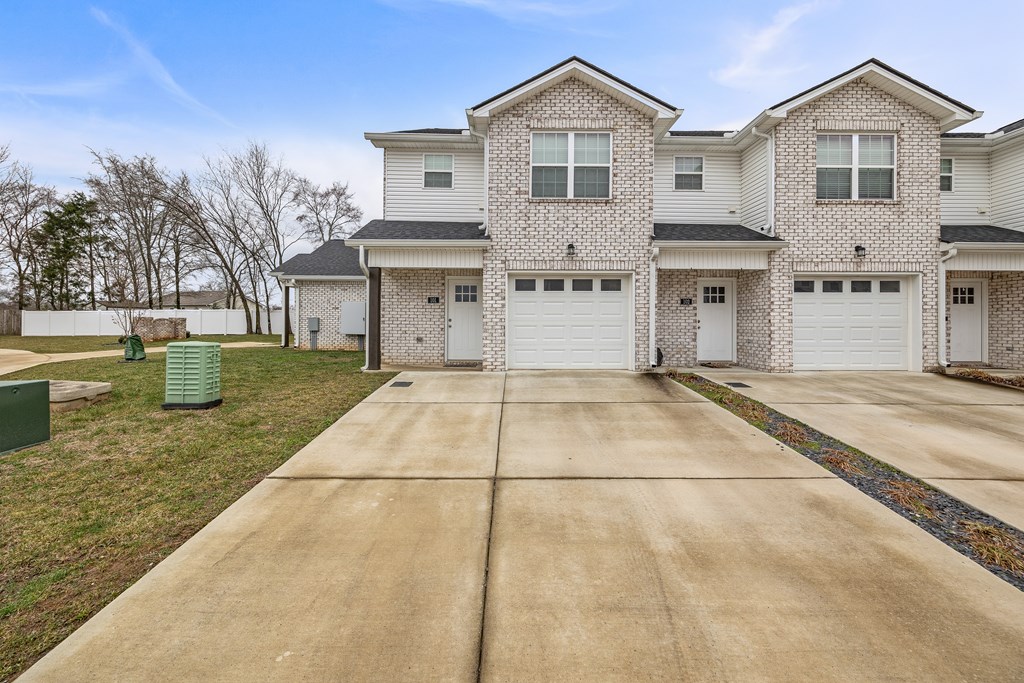 A large house with a driveway in front.