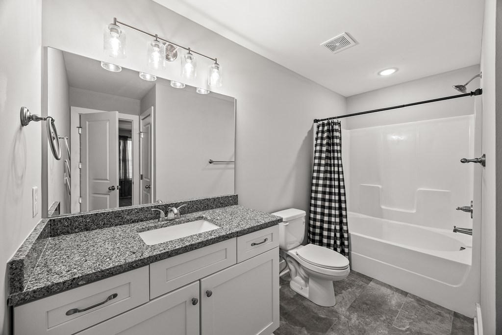 A bathroom with a sink, toilet, and bathtub.