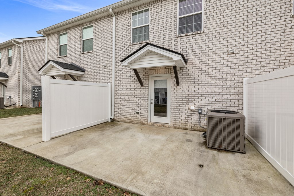 A brick house with a white garage door and a white fence.