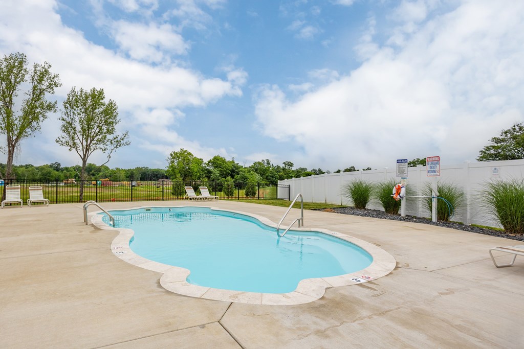 A large outdoor swimming pool surrounded by a fence.