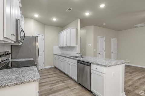 A kitchen with white cabinets and a granite countertop.