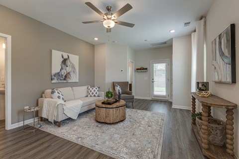 A living room with a white couch and a painting of a horse on the wall.
