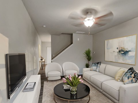 A living room with a white couch, a black coffee table, and a flat screen TV.