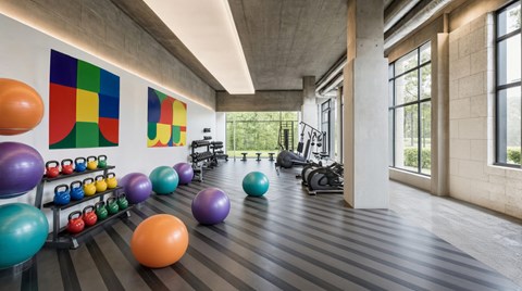 A gym with a row of kettlebells and a row of exercise balls.