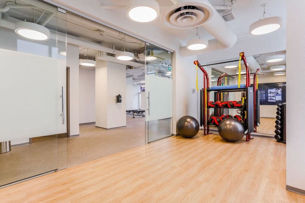 a workout room with weights and mirrors in a modern office building