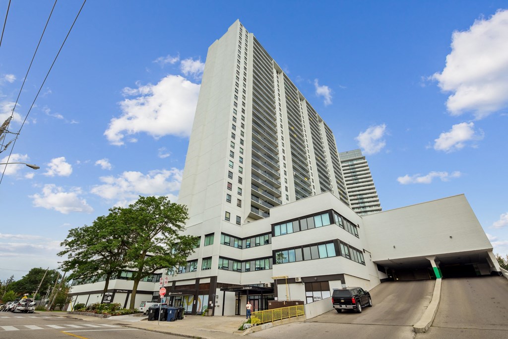 a tall white building with a street in front of it