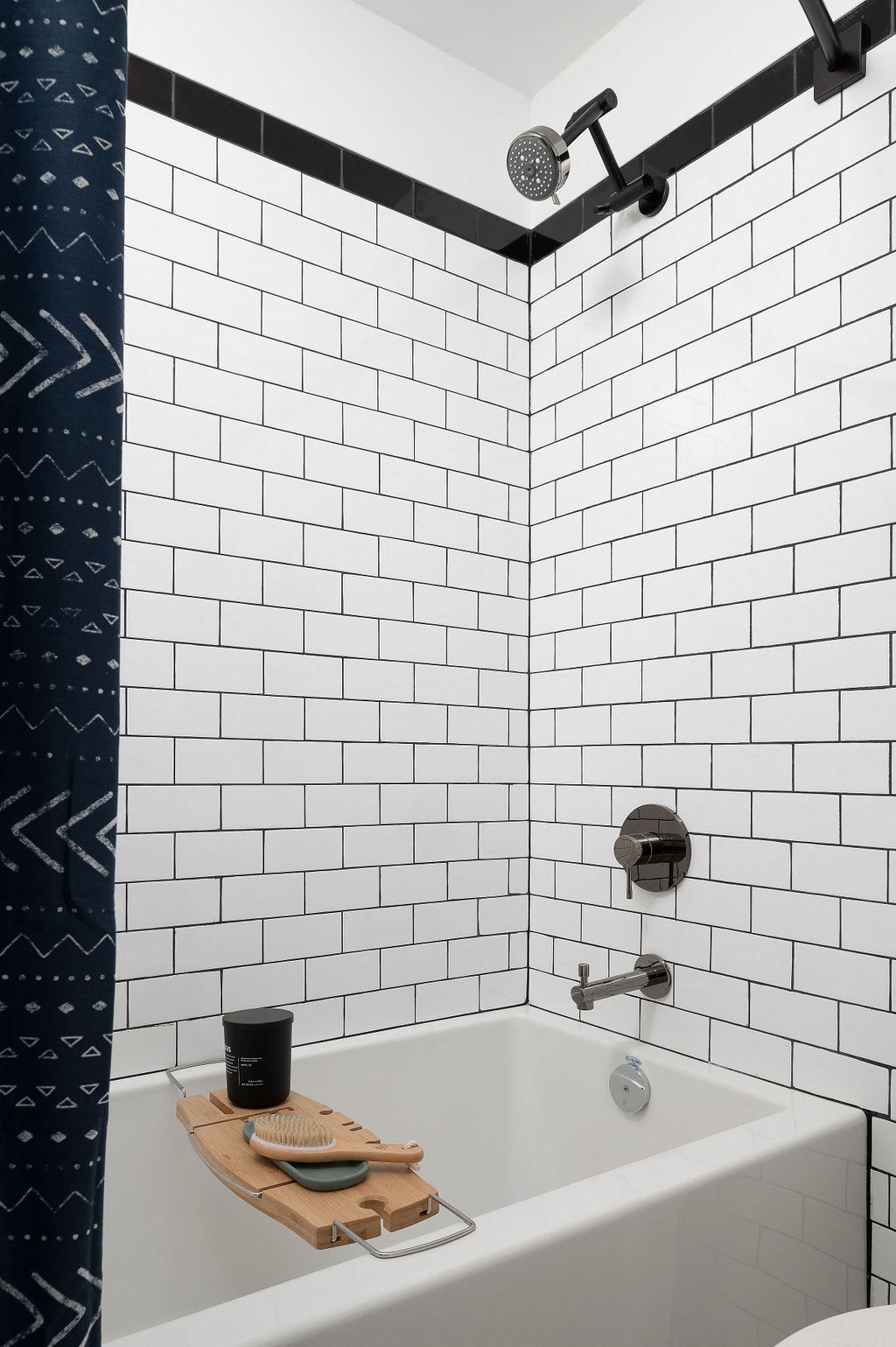 a bathroom with white subway tile and a shower and a tub