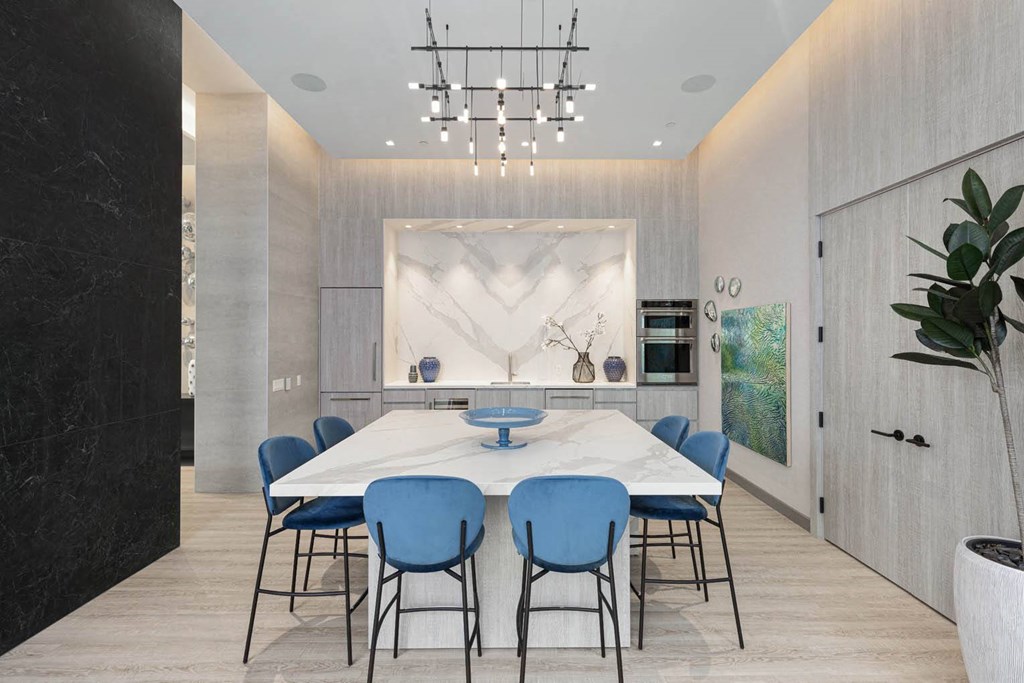 a dining room with a marble table and blue chairs
