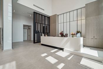 a large lobby with a reception desk and a glass door