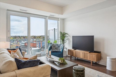 A modern living room with a large window overlooking a cityscape.