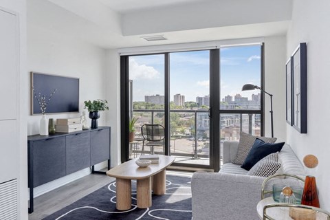 a living room with a view of the city and a couch and a table