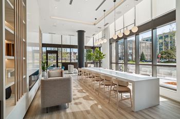 the lobby of a building with a long bar and chairs