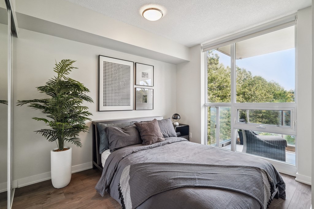 a bedroom with a large window and a plant