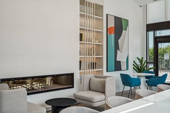 a living room with a fireplace and chairs and tables