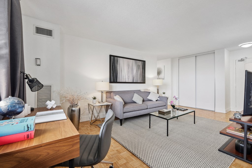 a living room with a couch and a desk and a tv
