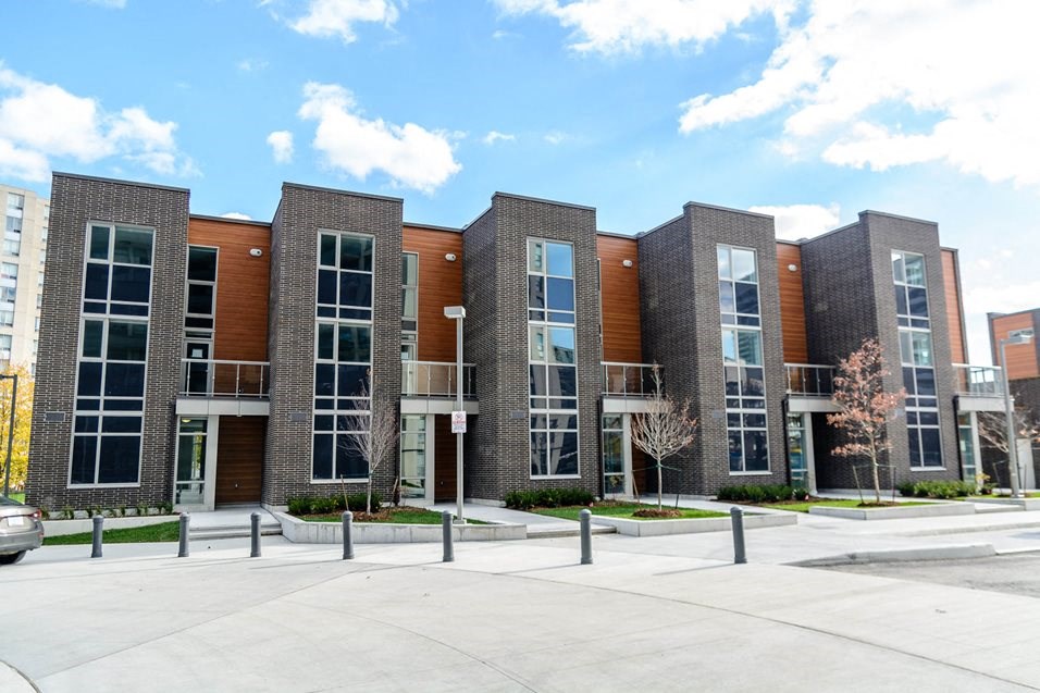 a row of brick apartment buildings with a parking lot