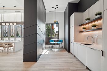a kitchen with white cabinets and a table with a blue chair